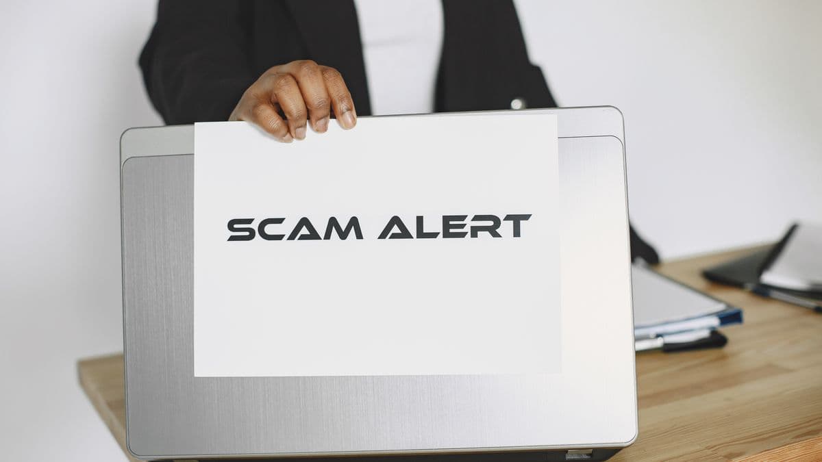 A scam alert on a laptop warning of investment fraud