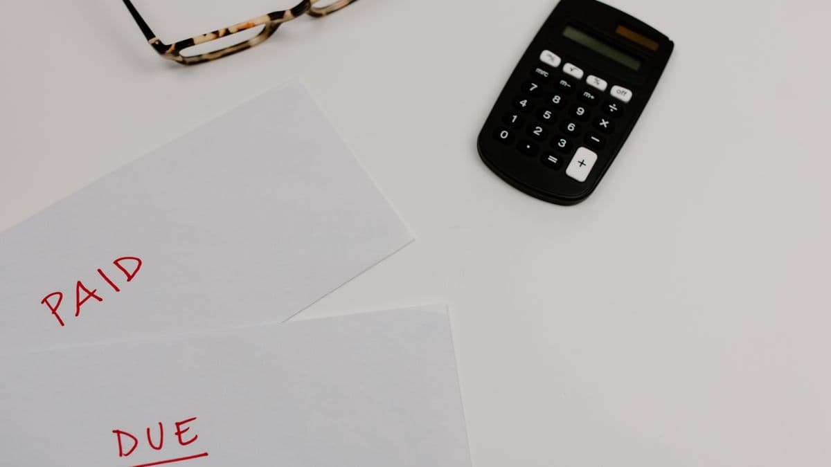 Financial papers and a calculator weighing good and bad debt