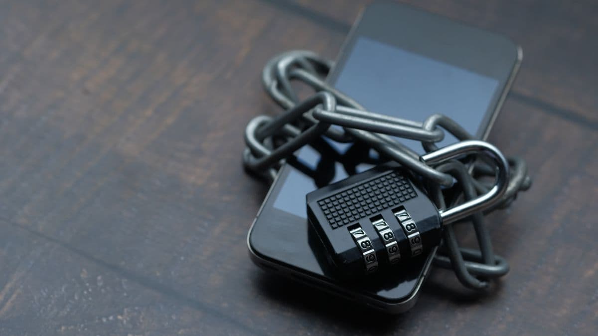 A smartphone secured with a padlock for mobile money safety