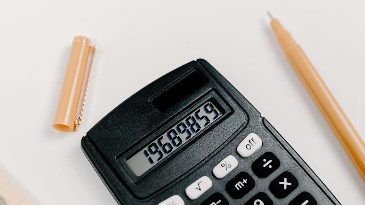 A calculator and coins used to plan a monthly budget