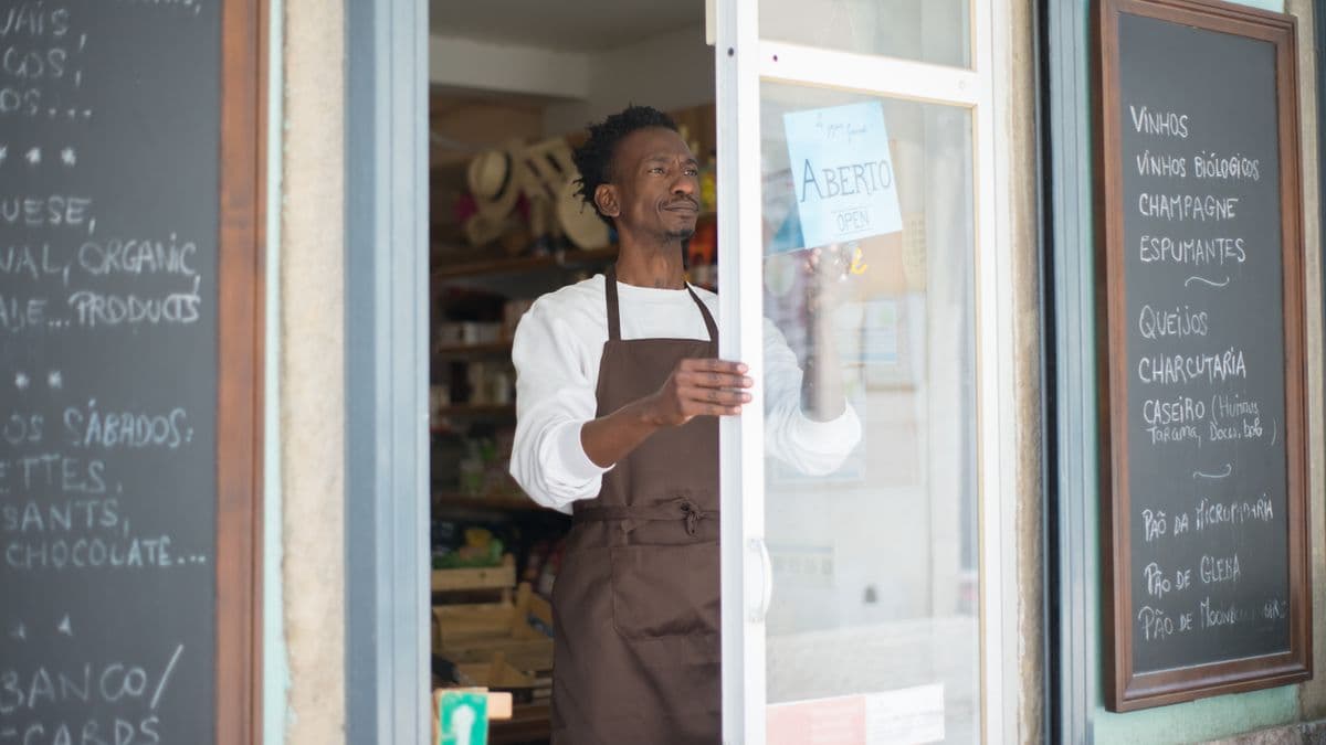 A shop owner opening their store, managing irregular income