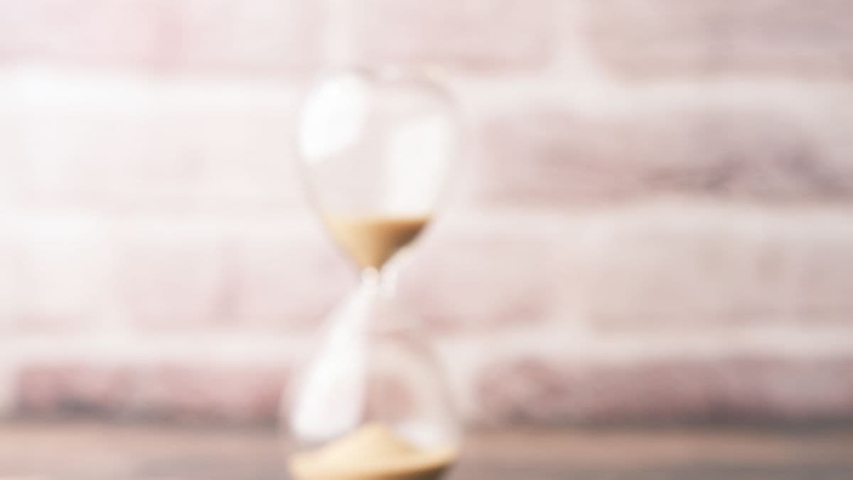 Coins and an hourglass showing saving versus investing over time